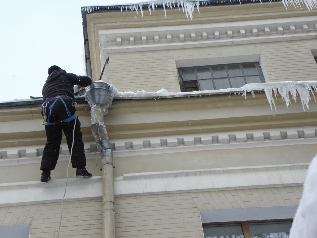 Сход снега с крыши, работают альпинисты